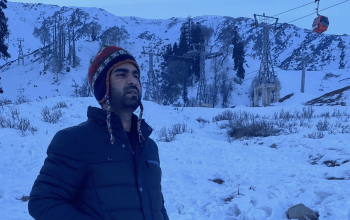 Alt Text: Skier enjoying skiing on snow-covered Gulmarg slopes with Himalayan backdrop.