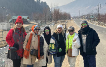 A scenic view of Kashmir with mountains and traditional architecture, representing its history and culture.